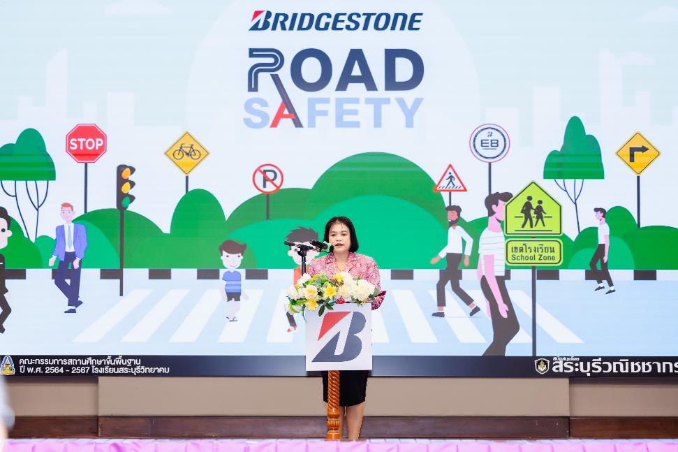 A person standing in front of a large sign Description automatically generated